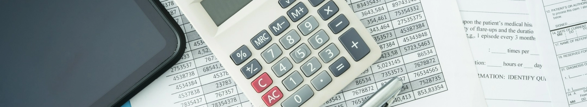 Tablet i kalkulator na wydrukowanych tabelkach tabelkach